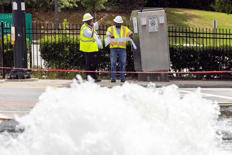 Workers take care of a water main break at Joseph E. Boone Boulevard and James P. Brawley Drive in Atlanta on Friday, May 31, 2024. (Arvin Temkar / AJC)