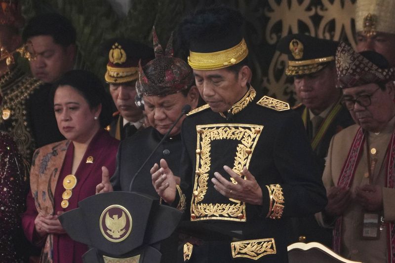 Indonesian President Joko Widodo, center, House Speaker Puan Maharani, left, and Defense Minister and president-elect Prabowo Subianto, second left, pray during a ceremony marking Indonesia's 79th anniversary of independence at the new presidential palace in its future capital of Nusantara, a city still under construction on the island of Borneo, Saturday, Aug. 17, 2024. (AP Photo/Achmad Ibrahim)