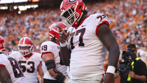 Georgia offensive lineman Amarius Mims reacts after Georgia wide receiver Marcus Rosemy-Jacksaint (not pictured) scored a touchdown during the first quarter against Tennessee at Neyland Stadium, Saturday, November 18, 2023, in Knoxville, Tn. Mims was wearing #77 to honor the late Devin Willock. (Jason Getz / Jason.Getz@ajc.com)