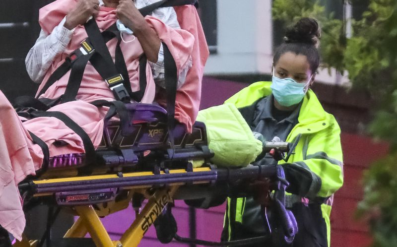 Grady ambulance crews wear masks and protective clothing like this emergency medical services worker does on Thursday, April 23, 2020, during a call on Wilbur Avenue in Atlanta. (JOHN SPINK/JSPINK@AJC.COM)