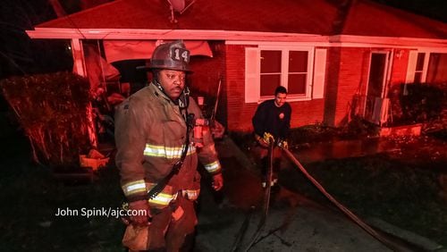 Lt. Brandon Lewis (left) and firefighter Brian Munoz of Engine 14 is one of several firefighters who rescued a woman and her dog from her burning home in southwest Atlanta on Friday.
