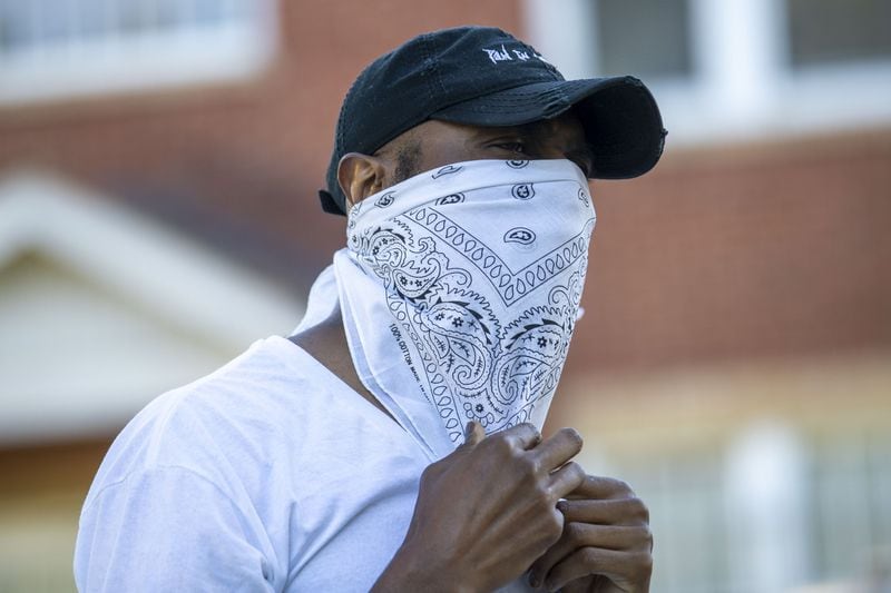 John Cooper adjusts his makeshift mask, white bandana, around his face before starting his 30-minute pull-up portraits session with photographer Melissa Alexander in Atlanta's West End community, Friday, May 1, 2020. "It's good to get out," said Cooper. ALYSSA POINTER / ALYSSA.POINTER@AJC.COM