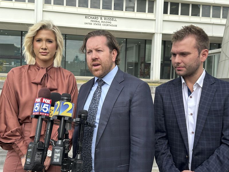 Reality TV stars Savannah Chrisley, left, and Chase Chrisley, right, look on as their mother's lawyer addresses reporters outside a federal courthouse in Atlanta on Wednesday, Sept. 25, 2024 after their mother, Julie Chrisley, was re-sentenced to serve seven years in prison. (AP Photo/Kate Brumback)