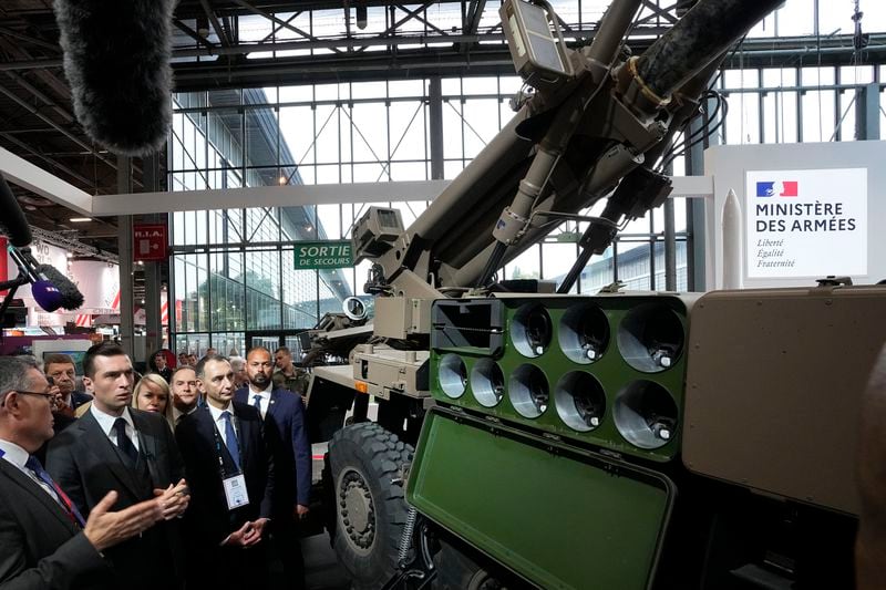 Jordan Bardella, second left, president of the far-right National Front party, looks at a Caesar self-propelled howitzer at the Eurosatory Defense and Security exhibition, Wednesday, June 19, 2024 in Villepinte, north of Paris. Jordan Bardella, hoping to become France's prime minister, appealed Tuesday to voters to hand his party a clear majority after French President Emmanuel Macron's announcement on June 9 that he was dissolving France's National Assembly, parliament's lower house.( AP Photo/Michel Euler)