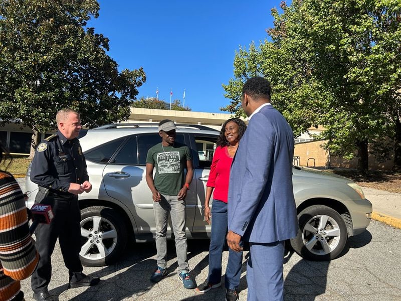 Atlanta police Interim Chief Darin Schierbaum (left) and Mayor Andre Dickens (right) speak with Bera Green after she turns in three guns she found at her mother's home.