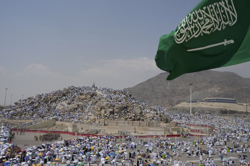 Muslim pilgrims gather at top of the rocky hill known as the Mountain of Mercy, on the Plain of Arafat, during the annual Hajj pilgrimage, near the holy city of Mecca, Saudi Arabia, Saturday, June 15, 2024. Masses of Muslims gathered at the sacred hill of Mount Arafat in Saudi Arabia for worship and reflection on the second day of the Hajj pilgrimage. (AP Photo/Rafiq Maqbool)