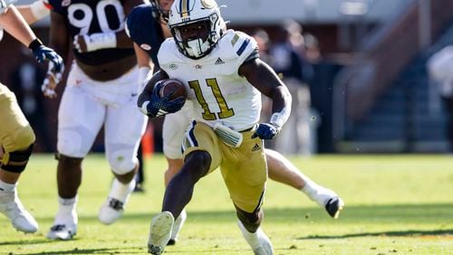 Georgia Tech running back Jamal Haynes (11) runs for a gain against the Virginia defense during the first half of an NCAA college football game Saturday, Nov. 4, 2023, in Charlottesville, Va. (AP Photo/Mike Caudill)