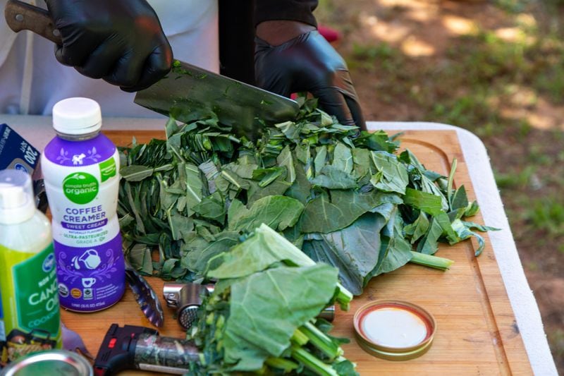 Musa Hasan cuts up some fresh collards for lunch at Bread and Butter Farms in Monroe. Phil Skinner for The Atlanta Journal-Constitution 