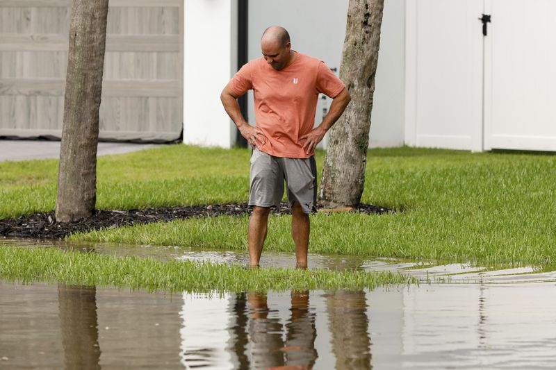 Eric Midili, 45, examines and walks around a flooded street around the Sunset Park neighborhood as Hurricane Helene makes its way toward the Florida panhandle on Thursday, Sept. 26, 2024, in Tampa, Fla. (Jefferee Woo/Tampa Bay Times via AP)