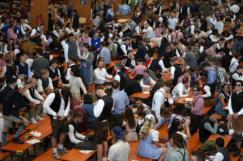 Visitors secured their place in a beer tent, awaiting the start of the 189th 'Oktoberfest' beer festival in Munich, Germany, Saturday, Sept. 21, 2024. (AP Photo/Matthias Schrader)