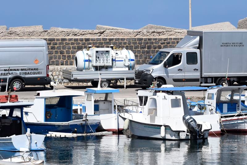 Italian Navy scuba divers set a hyperbaric chamber as they work at the scene of the search for a missing boat, in Porticello, southern Italy, Thursday, Aug. 22, 2024. Rescue teams and divers returned to the site of a storm-sunken super yacht to search for one person, who are believed to be still trapped in the hull 50 meters (164-feet) underwater. (AP Photo/Salvatore Cavalli)