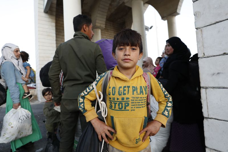 A Syrian boy poses for a picture as he flees the war in Lebanon with his family, at the Syrian-Lebanese border crossing in Jdeidet Yabous, Syria, Wednesday, Sept. 25, 2024. (AP Photo/Omar Sanadiki)