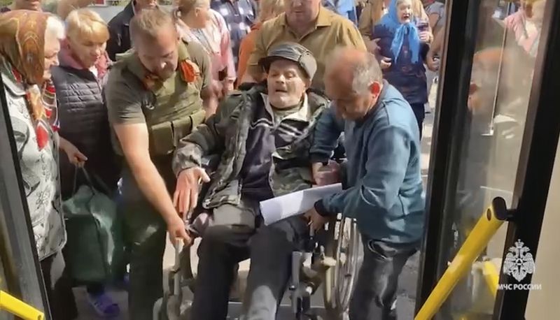 In this image made from video provided by Russian Emergency Situations Ministry press service, people board a bus during evacuation from a fighting between Russian and Ukrainian forces in Belovsky district, Kursk region, Russia, Monday, Aug. 12, 2024. (Ministry of Emergency Situations press service via AP)