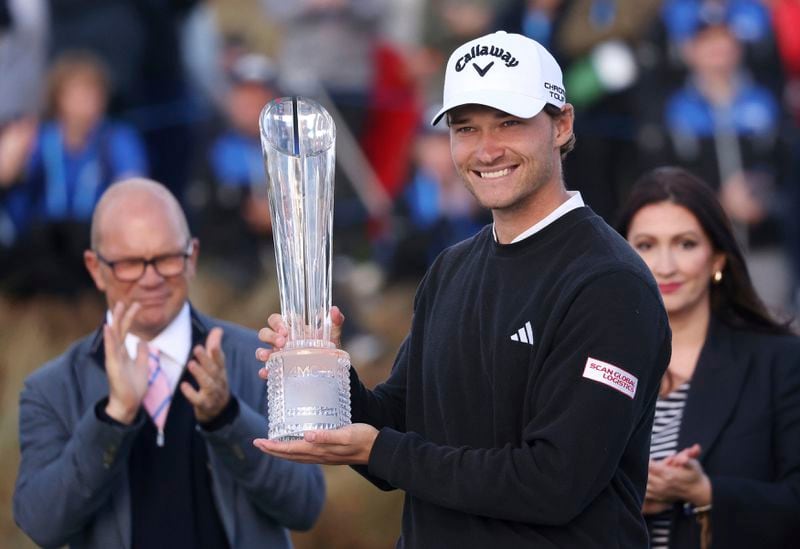 Denmark's Rasmus Hojgaard celebrates with the trophy after winning the Amgen Irish Open 2024 at Royal County Down in Newcastle, County Down, England, Sunday Sept. 15, 2024. (Peter Morrison/PA via AP)