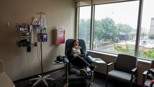 Emily Domhoff, diagnosed in her late 20s with colon cancer, sits in June with a saline drip IV after having her chemotherapy infusion pump removed. MUST CREDIT: Jahi Chikwendiu/The Washington Post