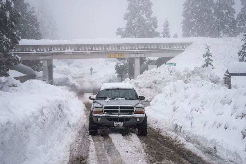 FILE - A truck drives along snow berms in Running Springs, Calif., Tuesday, Feb. 28, 2023. (AP Photo/Jae C. Hong, File)