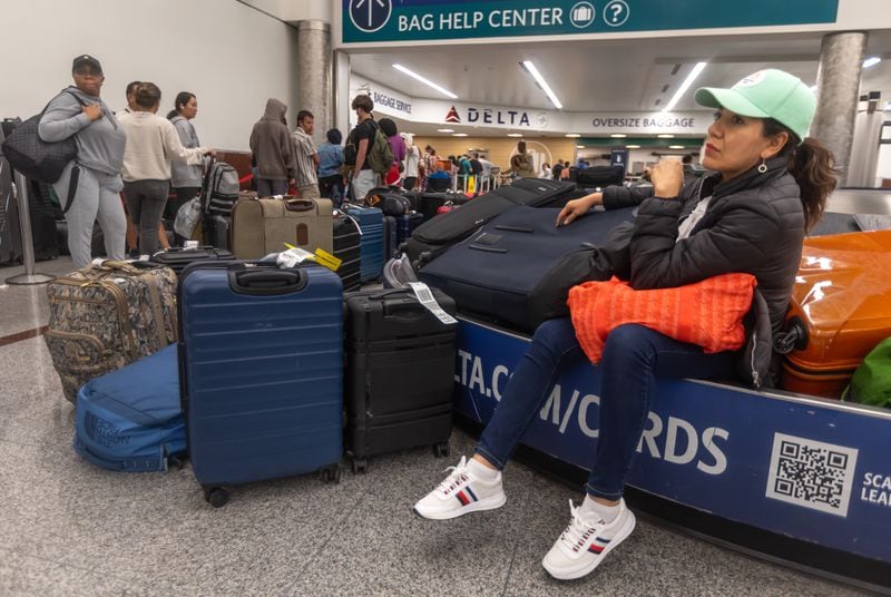 Katina Noriega, from Mexico, waits for her luggage issues to be worked out in the Delta Air Lines baggage claim as long lines and clusters of passengers sleeping on backpacks and folded blankets were spread throughout the Hartsfield-Jackson International Airport domestic terminal Monday morning, July 22, 2024. (John Spink/AJC)