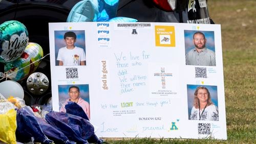 A poster with images of victims Christian Angulo, top left, Richard Aspinwall, top right, Mason Schermerhorn, bottom left, and Cristina Irimie is displayed at a memorial outside Apalachee High School, Friday, Sept. 6, 2024, in Winder, Ga., following a shooting at the school earlier in the week. (Arvin Temkar/Atlanta Journal-Constitution via AP)