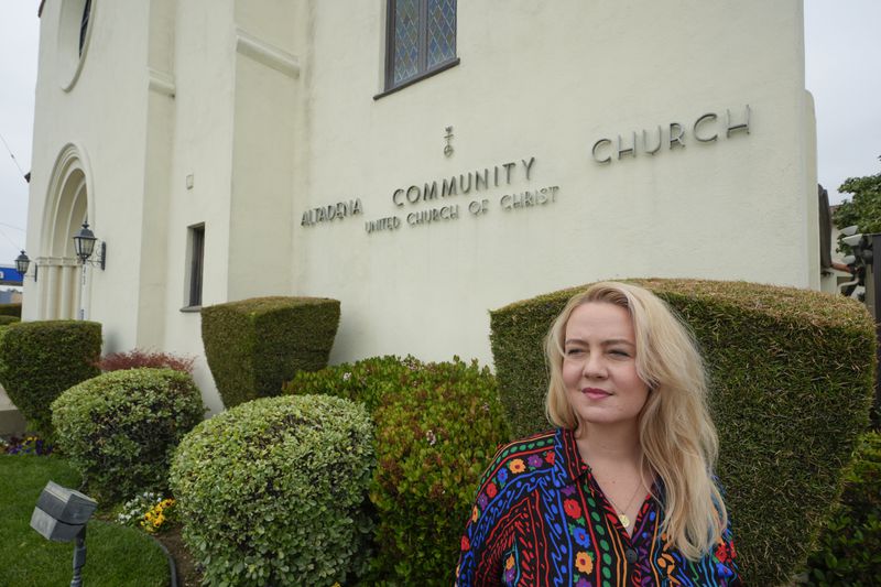 Pastor Ruth Schmidt poses for a picture at the Altadena Community Church in Altadena, Calif., on Tuesday, May 21, 2024. Schmidt, who now serves as a pastor at Claremont Presbyterian Church and is on track to be ordained in the United Church of Christ, said she would like to see faculty and staff at Fuller get the same protections as students. Fuller Theological Seminary, an evangelical school is deliberating whether to become more open to LGBTQ+ students who previously faced possible expulsion if found to be in a same-sex union.(AP Photo/Damian Dovarganes)