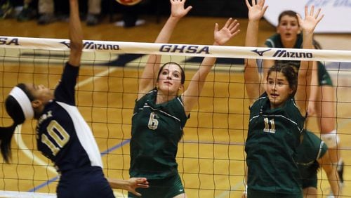 (left to right) St. Pius X Catholic's #10 Leah Hardeman spikes the ball against Blessed Trinity's #6 Maggie Rick & #11 Remy Smith during the 2013 Georgia High School State Volleyball GHSA Class AAA finals at Marietta High School.