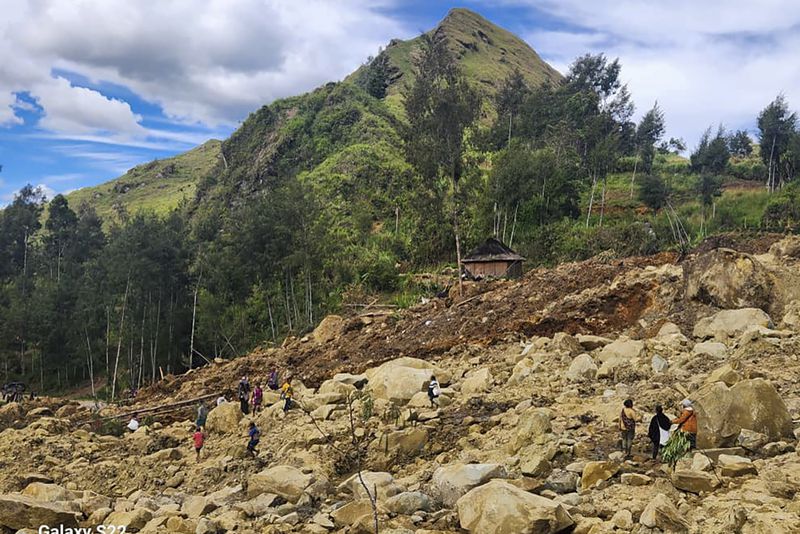 In this image supplied by the International Organization for Migration, villagers search amongst the debris from a landslide in the village of Yambali in the Highlands of Papua New Guinea, Monday, May 27, 2024. (Mohamud Omer/International Organization for Migration via AP)