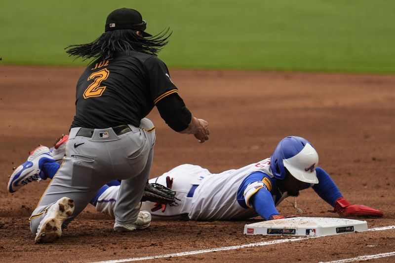 Atlanta Braves' Ozzie Albies (1) slides back to first base against Pittsburgh Pirates first baseman Connor Joe (2) in the first inning of a baseball game, Saturday, June 29, 2024, in Atlanta. (AP Photo/Mike Stewart)