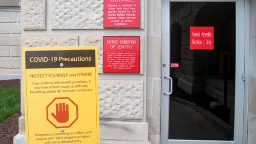 In January, a sign warning visitors with COVID-19 symptoms to stay out of the Georgia State Capitol building was displayed near the entrance for legislators in downtown Atlanta, (Alyssa Pointer / Alyssa.Pointer@ajc.com)