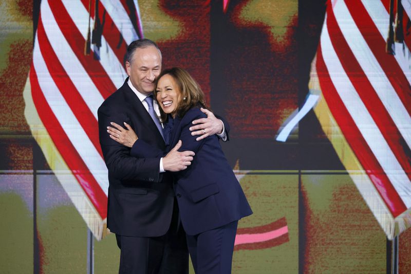 Second gentleman Doug Emhoff, left, hugs Democratic presidential nominee Vice President Kamala Harris during the final day of the Democratic National Convention Thursday, Aug. 22, 2024 in Chicago. (Gabrielle Lurie/San Francisco Chronicle via AP)