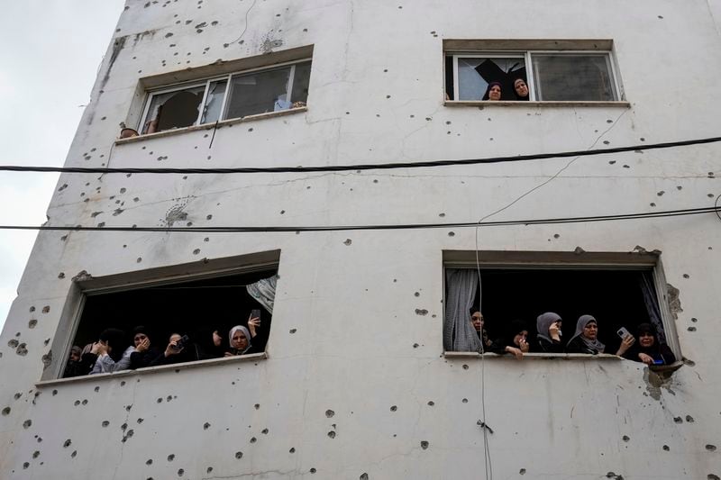 Mourners watch the funeral of Palestinian men who were killed during an Israeli military operation, from a building damaged with bullet holes, in Jenin, West Bank, Friday, Sept. 6, 2024. (AP Photo/Majdi Mohammed)