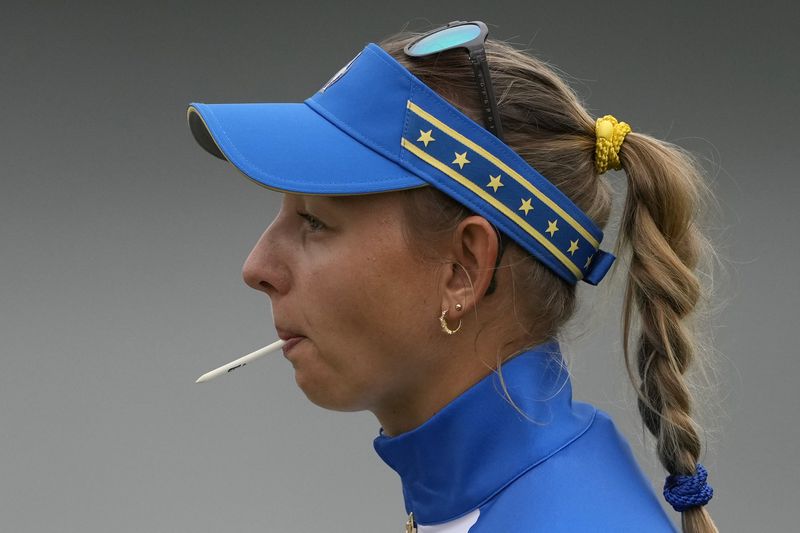 Europe's Emily Pedersen holds a tee in her mouth on the 10th hole during a Solheim Cup golf tournament foursomes match at Robert Trent Jones Golf Club, Friday, Sept. 13, 2024, in Gainesville, VA. (AP Photo/Matt York)