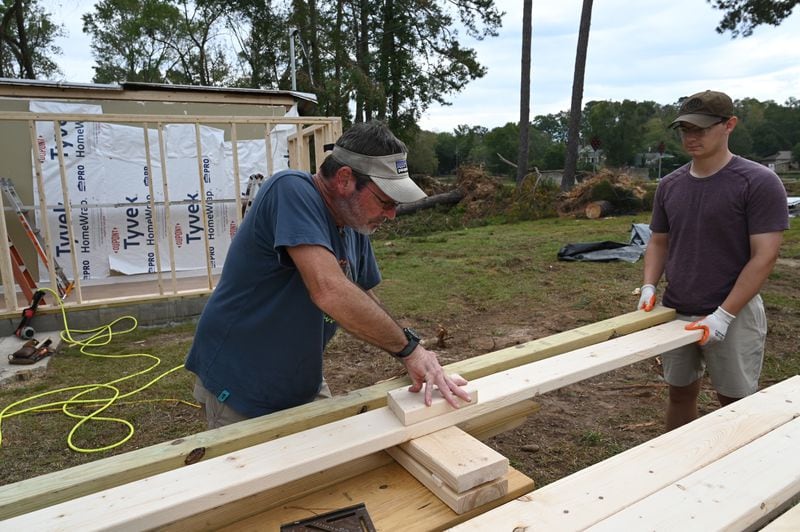 Michael Armstrong (izquierda), asistido por Will Dorn, reconstruye parte de su casa dañada por el huracán Helene, el viernes 4 de octubre de 2024, en Evans. (Hyosub Shin/AJC)