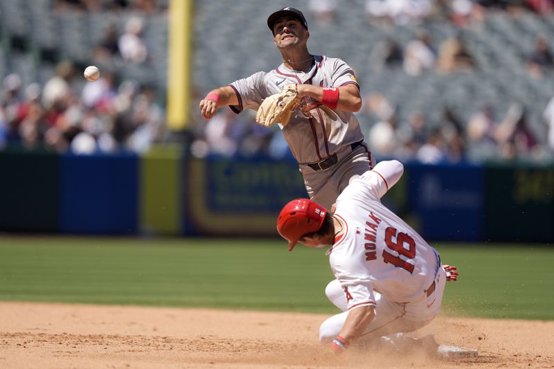 Atlanta Braves second baseman Whit Merrifield, top, throws out Los Angeles Angels' Taylor Ward at first to complete a double play after forcing out Angels' Mickey Moniak (16) to end the fifth inning of a baseball game, Sunday, Aug. 18, 2024, in Anaheim, Calif. (AP Photo/Ryan Sun)