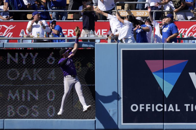 Colorado Rockies left fielder Nolan Jones can't reach a ball hit by Los Angeles Dodgers' Kiké Hernández for a two-run home run during the seventh inning of a baseball game, Sunday, Sept. 22, 2024, in Los Angeles. (AP Photo/Mark J. Terrill)