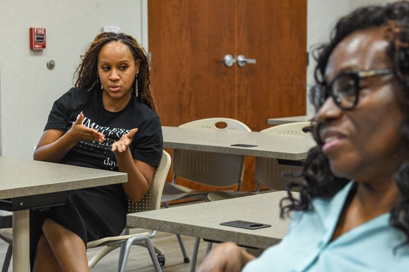 Sukari Johnson (left), from Lake Spivey, interacts with another audience member at a community class hosted by Emory University's Center for AI Learning in McDonough on Tuesday, July 2, 2024.  (Ziyu Julian Zhu / AJC)