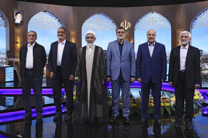 In this picture made available by Iranian state-run TV, IRIB, presidential candidates for June 28, election from left to right: Masoud Pezeshkian, Alireza Zakani, Mostafa Pourmohammadi, Amirhossein Ghazizadeh Hashemi, Mohammad Bagher Qalibaf, and Saeed Jalili pose for a photo after the conclusion of their debate at the TV studio in Tehran, Iran, Tuesday, June 25, 2024. (Morteza Fakhri Nezhad/IRIB via AP)