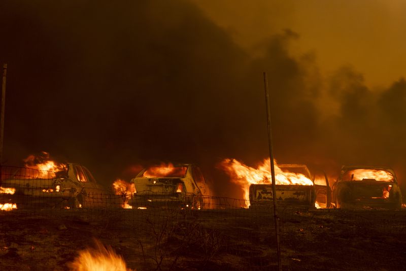 Vehicles burn as the Airport Fire sweeps through Tuesday, Sept. 10, 2024, in El Cariso, an unincorporated community in Riverside County, Calif. (AP Photo/Etienne Laurent)