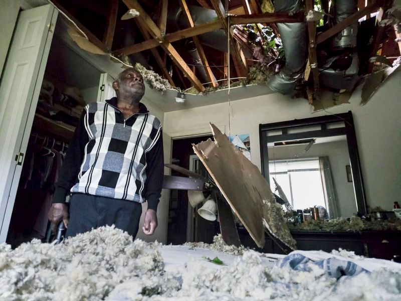 McKinley Moore inspects the damage on his home after a tree fell over his bedroom after Hurricane Helen passed the area Friday, Sept. 27, 2024 in Charlotte, N.C. (Khadejeh Nikouyeh/The Charlotte Observer via AP)