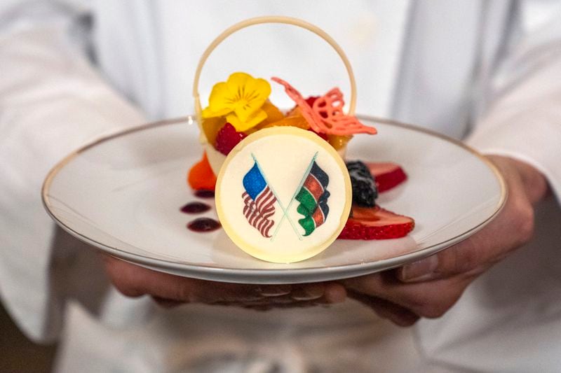White House Executive Pastry Chef Susie Morrison holds a dessert of a white chocolate basket with banana ganache, raspberries, peaches, and candied lime zest, during a preview of the State Dinner with Kenya, Wednesday, May 22, 2024, at the White House in Washington. (AP Photo/Jacquelyn Martin)