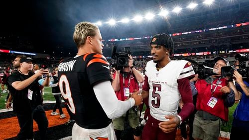 Washington Commanders quarterback Jayden Daniels (5) talks with Cincinnati Bengals quarterback Joe Burrow (9) after an NFL football game, Monday, Sept. 23, 2024, in Cincinnati. The Commanders won 38-33. (AP Photo/Jeff Dean)