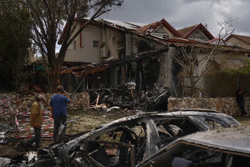 People look at the site hit by a rocket fired from Lebanon, in Moreshet, northern Israel, on Sunday, Sept. 22, 2024. (AP Photo//Ariel Schalit)