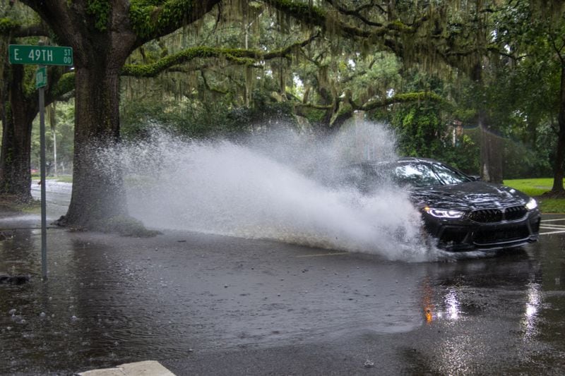 A car drives through a flooded street in Savannah.