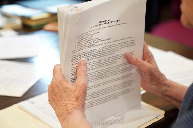 Sister Barbara McCracken looks through prior resolutions filed against various corporations, including Alphabet, Meta, Netflix and Chevron, at the Mount St. Scholastica Benedictine monastery in Atchison, Kan., Tuesday, July 16, 2024. McCracken currently serves in the monastery's business office helping with shareholder resolutions and investments. (AP Photo/Jessie Wardarski)