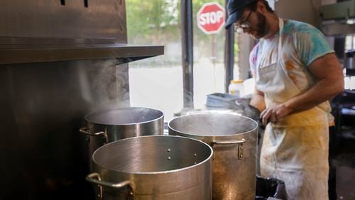 Line cook William Miracle works in the kitchen next to large pots that are boiling water at the restaurant, Sun in my Belly, in the Kirkwood neighborhood, Monday, June 3, 2024, in Atlanta. (Jason Getz / AJC)
