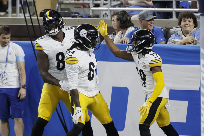 Pittsburgh Steelers running back Cordarrelle Patterson is greeted by tight end Darnell Washington (80) and wide receiver Calvin Austin III (19) after rushing for a 31-yard touchdown during the first half of an NFL preseason football game against the Detroit Lions, Saturday, Aug. 24, 2024, in Detroit. (AP Photo/Duane Burleson)