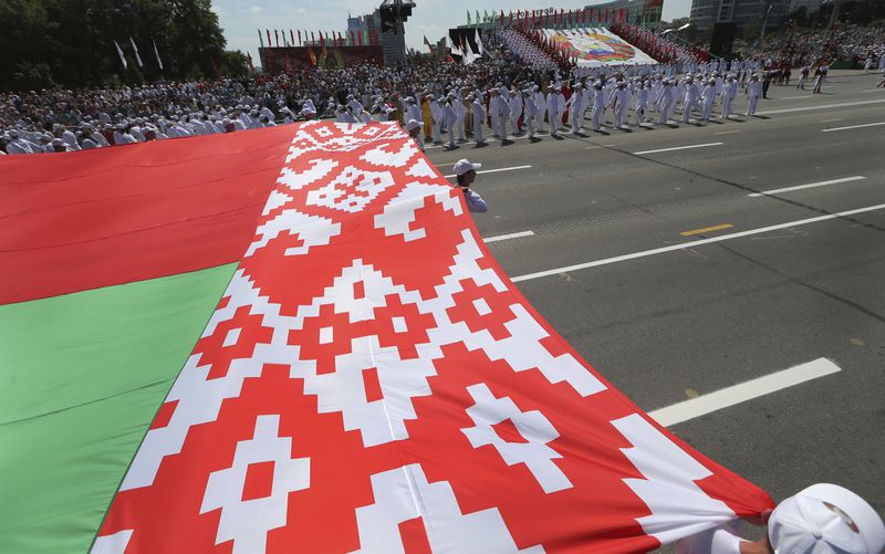 FILE - Belarusian athletes carry the country’s flag during celebrations marking Independence Day in Minsk, Belarus, on July 3, 2013. (AP Photo, File)