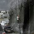 A Palestinian man climbs the separation wall at the town of al-Ram to illegally cross into Jerusalem, Sunday, Sept. 15, 2024. (AP Photo/Mahmoud Illean)