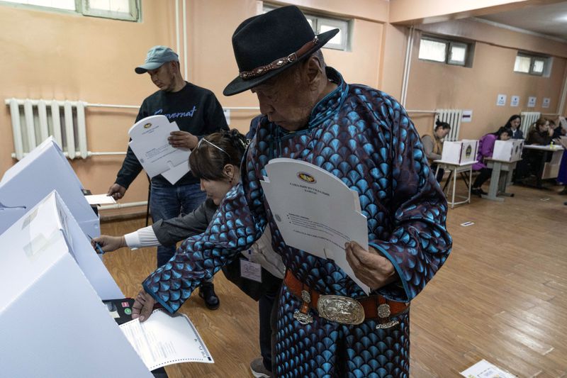 A Mongolian man feeds his vote into a counting machine at a polling station in the Ger District on the outskirts of Ulaanbataar, Mongolia, Friday, June 28, 2024. Voters in Mongolia are electing a new parliament on Friday in their landlocked democracy that is squeezed between China and Russia, two much larger authoritarian states. wld(AP Photo/Ng Han Guan)