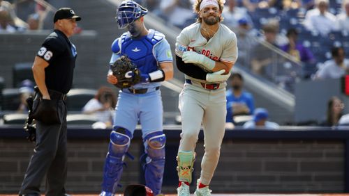 Philadelphia Phillies first base Bryce Harper holds his arm after betting hit by a pitch in the first inning of a baseball game against the Toronto Blue Jays in Toronto, Wednesday, Sept. 4, 2024. (Cole Burston/The Canadian Press via AP)