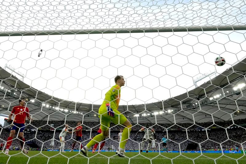 Germany's goalkeeper Manuel Neuer, center, looks at the ball as Spain's Mikel Merino scores his side's second goal during a quarter final match between Germany and Spain at the Euro 2024 soccer tournament in Stuttgart, Germany, Friday, July 5, 2024. (AP Photo/Antonio Calanni)