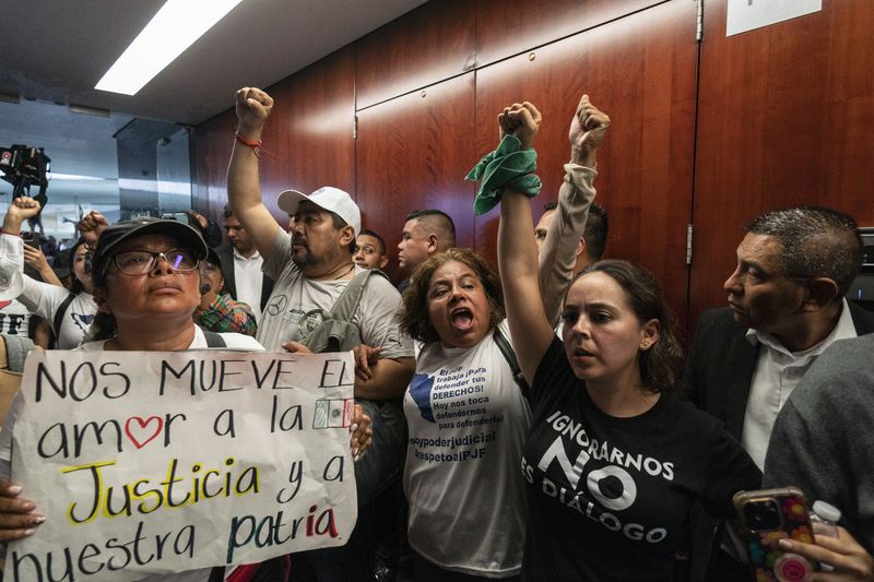 Protesters attempt to break into a Senate room in which lawmakers weigh the government's proposed judicial reform, which would make judges stand for election, in Mexico City, Tuesday, Sept. 10, 2024. (AP Photo/Felix Marquez)